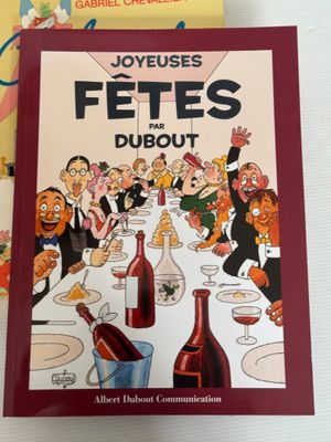 deux livres posés sur une table, avec une bouteille de vin et une bouteille de vin