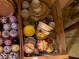 de nombreux bols et assiettes dans une caisse en bois posée par terre