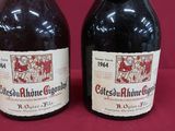 two bottles of red wine sitting next to each other on a table