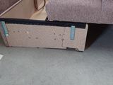 a couch that has a box under it on the floor