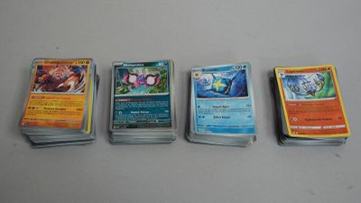 cinq types différents de cartes Pokémon disposées sur une table