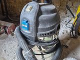 un aspirateur posé sur le sol d'une pièce