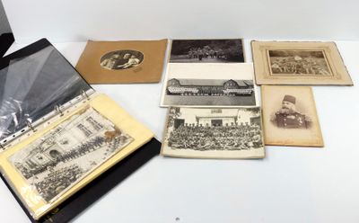 de nombreuses vieilles photos posées sur une table, à côté d'un ordinateur portable