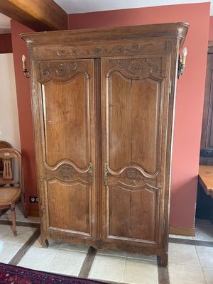 a large wooden armoire in the corner of a room