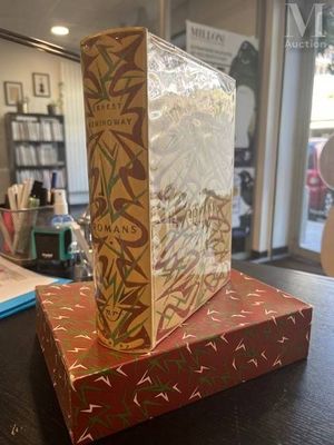 an empty box sitting on top of a wooden table next to a book