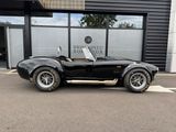an image of a black sports car parked in front of a building