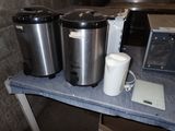 three coffee makers sitting on a table next to a microwave