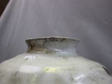 a white vase with a tag on it sitting on a table