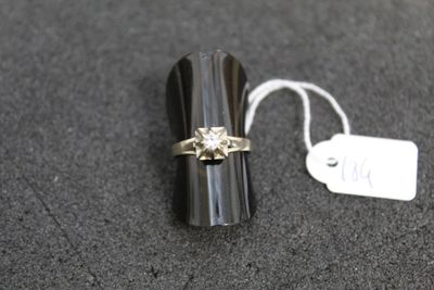 a ring with a diamond on it sitting next to a price tag