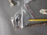 a small bag of sewing needles and a sewing needle next to a small bag of sewing needles
