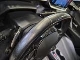a steering wheel in a car with a cell phone on the dashboard