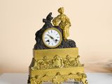 a gold clock sitting on top of a white table