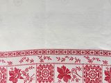 a red and white table cloth with red flowers on it