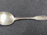 a silver spoon with a spoon handle on a gray surface