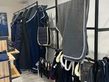 une photo d'un magasin de vêtements où des vêtements sont suspendus à un portemanteau