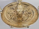 a gold plate with a candle on top of it