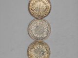 three gold and silver coins sitting on top of each other