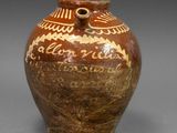 un vase marron et blanc posé sur une surface grise