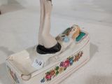 figurine en porcelaine représentant les jambes d'une femme sur un bateau orné de fleurs
