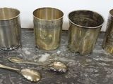 five cups and spoons sitting on a table next to each other