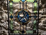 a stained glass window in the corner of a stone wall