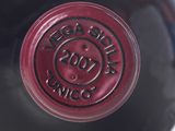 a close up of a bottle of wine with a red cap