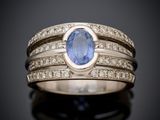 un gros plan d'une bague sertie d'un saphir bleu entouré de diamants