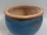 a blue bowl with a brown rim sitting on a white surface