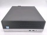 the hp desktop computer is on a white surface with a blue sticker on it