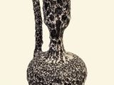 a black and white vase with a handle on a white background