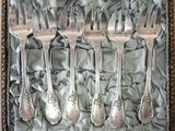 five forks and spoons in a box on a table