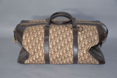 sac de voyage beige et marron, orné d'un motif monogramme et doté de poignées en cuir marron