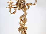 a gold candelab with a bunch of flowers on it