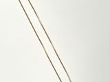 a close up of a necklace on a white surface with a white background
