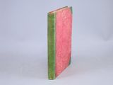a pink and green book sitting on a white surface
