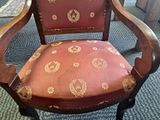 a red chair with a gold leaf pattern on it
