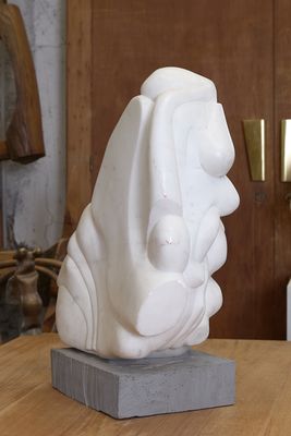 une sculpture blanche posée sur une table en bois dans une pièce
