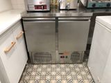 a stainless steel refrigerator in a kitchen with a tile floor