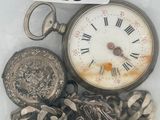 une montre de poche et un tas de pièces dans un sac