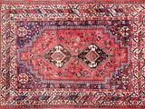 an antique persian rug with red and blue colors