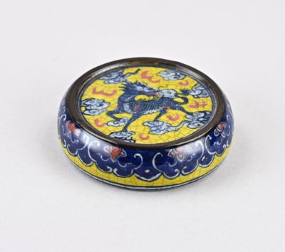 une petite boîte bleue et jaune sur laquelle est représenté un dragon