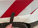a person holding a ruler that is on the side of a car