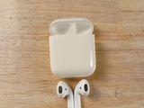 a pair of airpods sitting on a wooden table