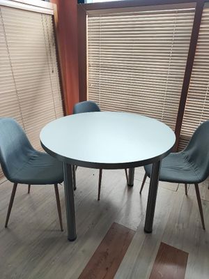 une table blanche et des chaises bleues dans une pièce