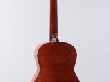 an old guitar hanging from a string on a white wall