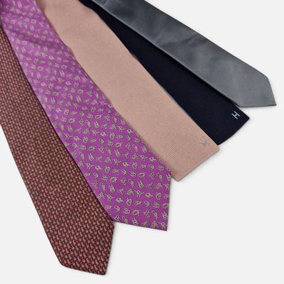 trois cravates de couleurs différentes sont alignées sur une surface blanche