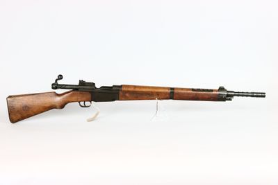 un fusil avec un canon en bois sur fond blanc