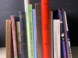une pile de livres posée sur une table près d'un mur noir
