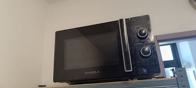un micro-ondes posé sur une étagère dans une pièce