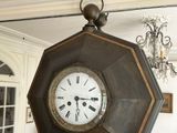 a large clock hanging from the ceiling in a living room